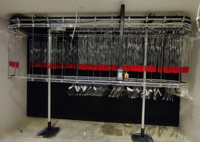 Railex System 742 two tier conveyor that shows our Railex extended hangers. These hang “up” hangers allow the operator to reach garments on the upper tier. This makes the space and the conveyor more useful for higher density. This system is an older system in a performance space for guest coat check.